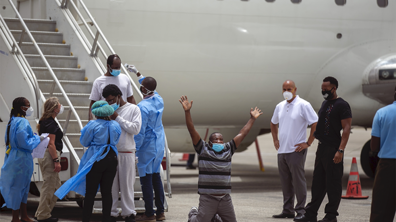 A Haitian man kneels on the tarmac at the Toussaint Louverture International Airport